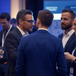 Professionals with name badges talking during a networking session at a corporate conference